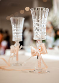 Close-up of ribbons tied to drinking glass on table