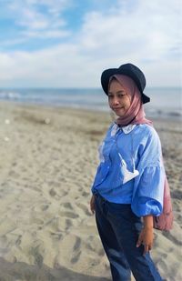 Portrait of smiling woman standing on beach