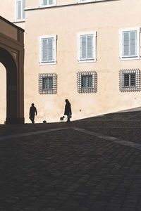 People walking on street by building