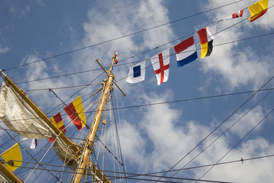 Low angle view of flags hanging against sky