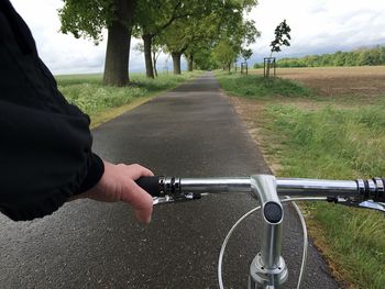 Close-up of man riding bicycle on road