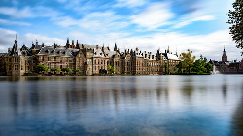 Binnenhof in front of river against cloudy blue sky