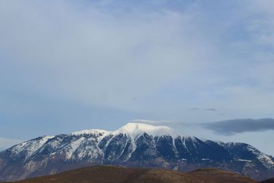 Low angle view of snowcapped mountains against sky