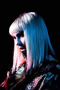 Portrait of woman with hair against black background