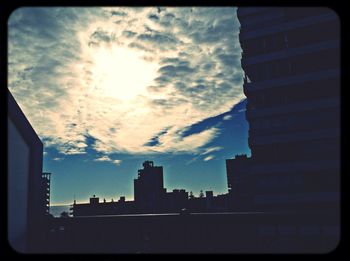 Low angle view of buildings against cloudy sky