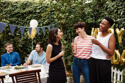 Cheerful friends toasting wine during birthday celebration