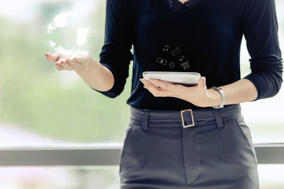 Midsection of man using mobile phone