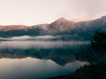 Scenic view of lake by mountains against sky