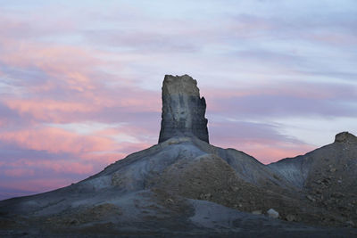 View of rock formation against cloudy sky