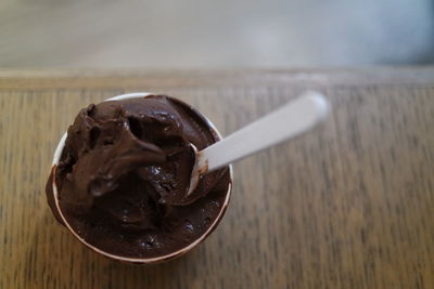 Close-up of chocolate with spoon in bowl on wooden table