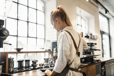 Side view of a woman standing in restaurant