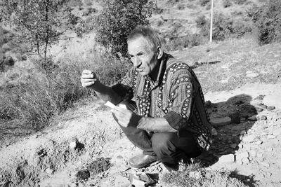 Full length of man sitting on mountain