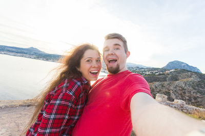 Portrait of smiling young couple against mountains