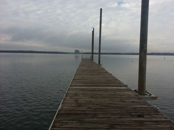 Wooden jetty on pier over sea against sky