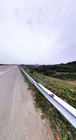 Empty road passing through field