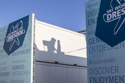 Low angle view of sign against blue sky