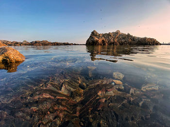 Scenic view of rock formation in sea against sky