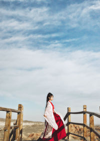 Rear view of woman standing against sky