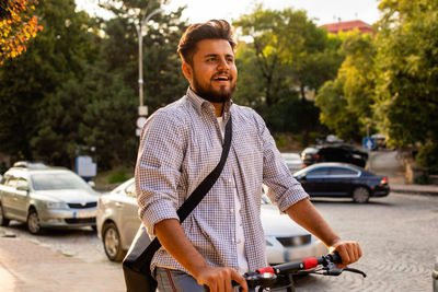 Portrait of young man sitting on street