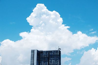 Low angle view of modern building against cloudy sky