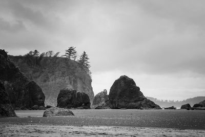 Rock formations by sea against sky