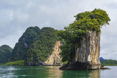 Scenic view of rock formation in water against sky