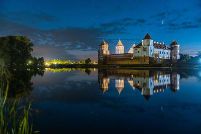 Comet neowise in a night landscape. mir castle in belarus. beautiful landscape with stars and comet