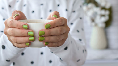 Close-up of hand holding coffee cup