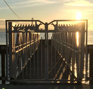 Pier on sea at sunset