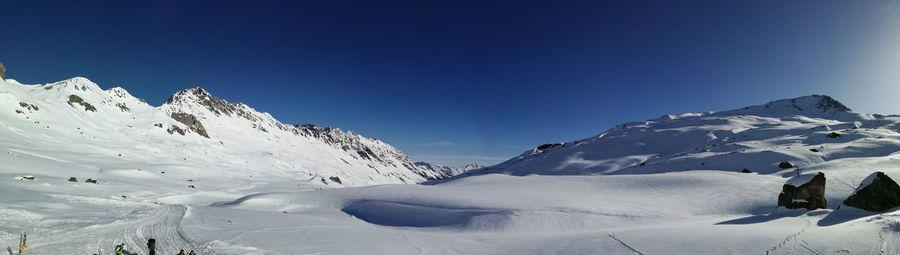 Scenic view of snowcapped mountains against clear blue sky