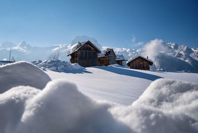 Scenic view of snow covered houses against sky during winter