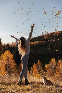 Woman standing by tree against sky