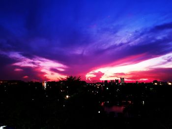 Silhouette buildings against sky at night