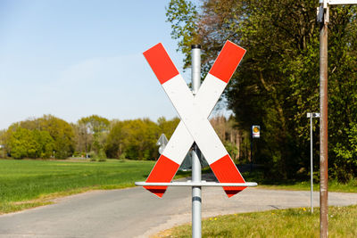 Railroad crossing with andreaskreuz in nature with blue sky