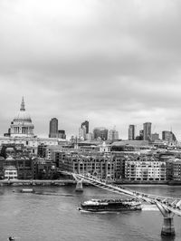 Passenger craft sailing on thames river under millennium bridge by st pauls cathedral