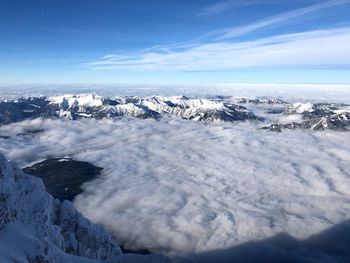 Scenic view of snowcapped mountains by sea against sky