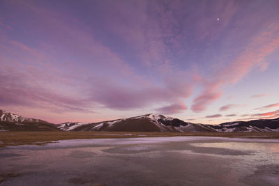 Scenic view of snowcapped mountains against sky during sunset in winter season