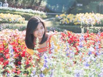 Portrait of smiling young woman with red flowers