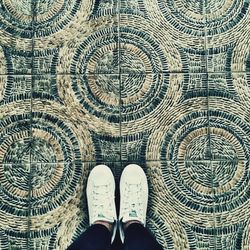 Low section of man standing on tiled floor