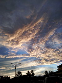 Low angle view of street light against cloudy sky