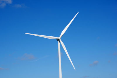 Low angle view of windmill against blue sky