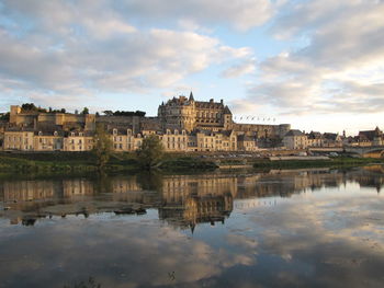 Buildings and sky reflecting on calm lake