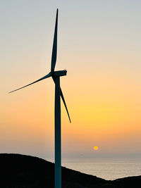 Low angle view of windmill against sky during sunset