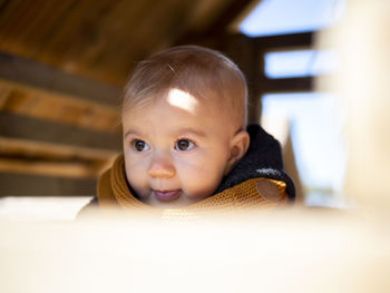 Close-up of cute baby girl looking away at home