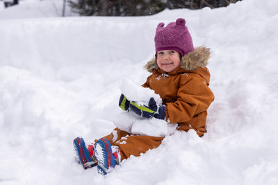 Portrait of woman skiing on snow covered field