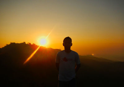 Silhouette man standing against sky during sunset