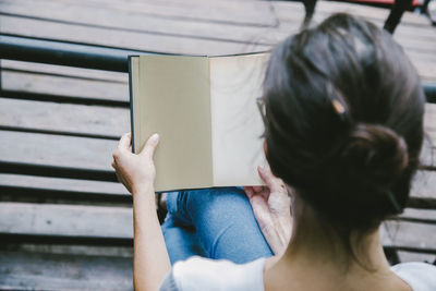 Rear view of woman reading book