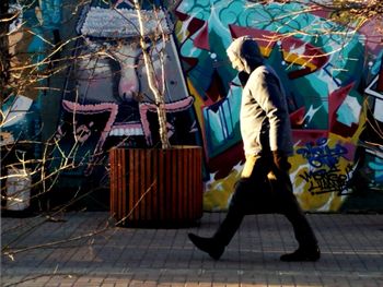 Low section of people walking on street in city