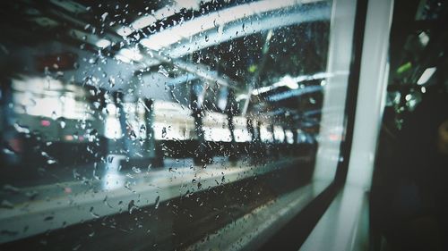 Railroad station platform seen from wet train window