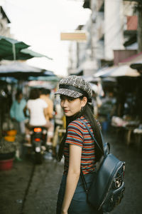 Woman wearing hat on street in city